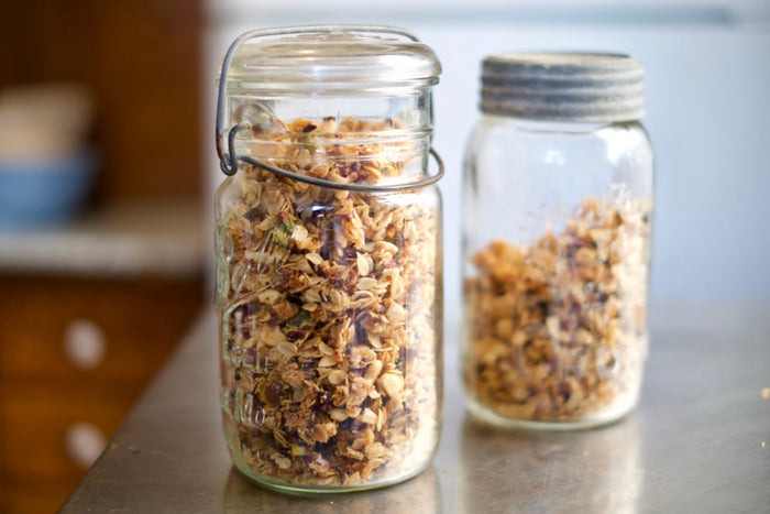 Nibby & Nutty Granola stored in glass jars and ready to be enjoyed.