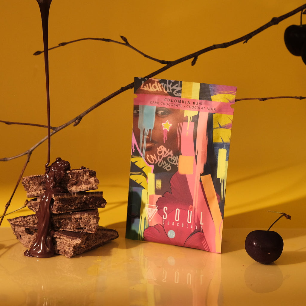 A package of colombia dark chocolate with cherries and nougat on a yellow background