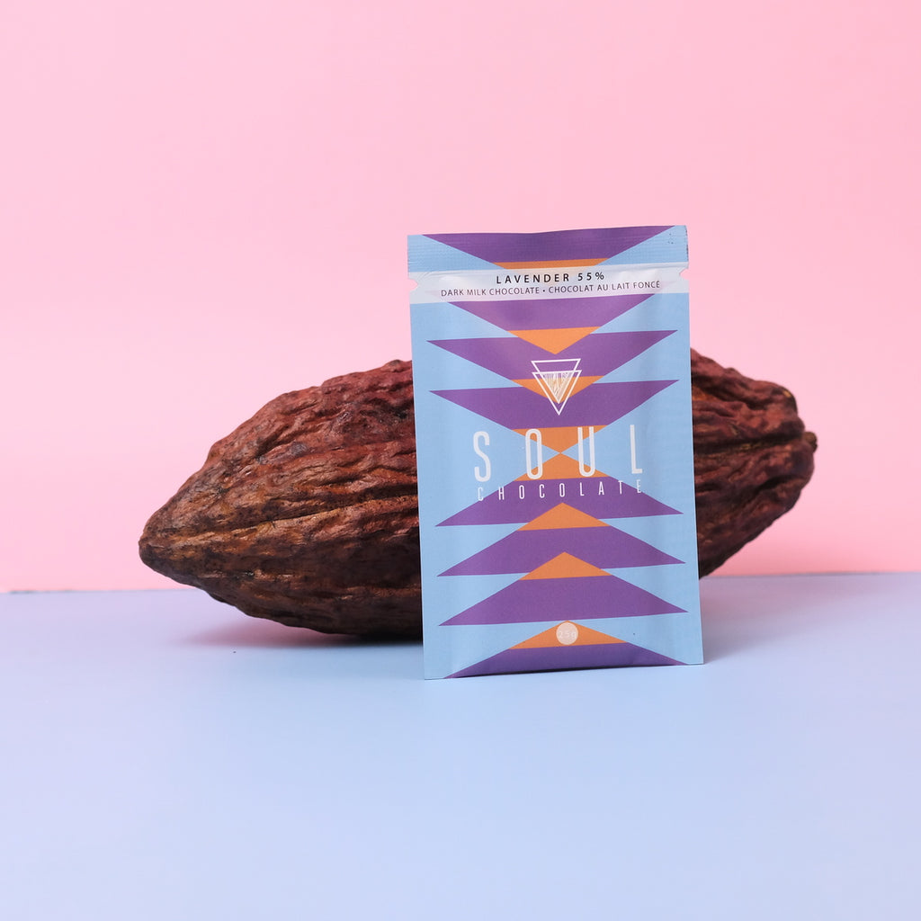 Soul Chocolates lavender chocolate bar packaging with cocoa beans on a pink and blue gradient background