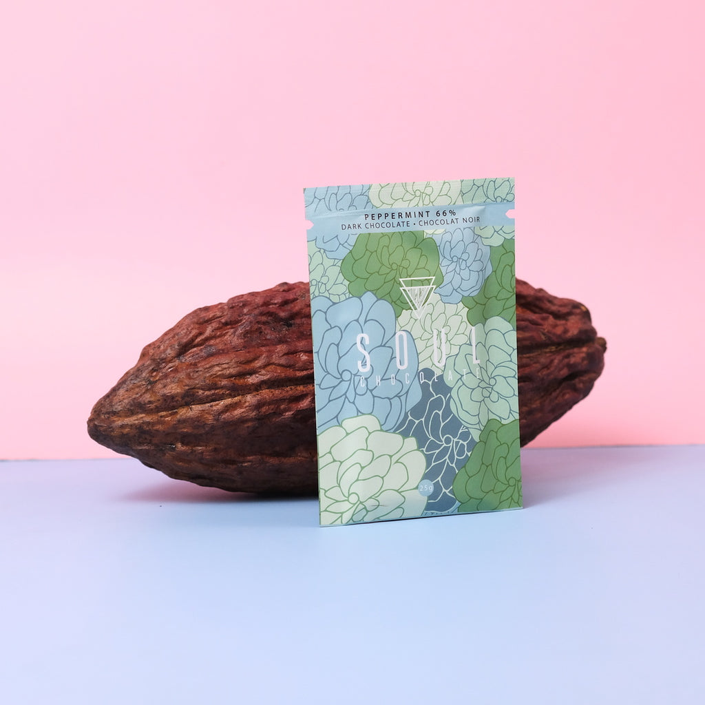 Soul chocolate bar green peppermint packaging with a cacao bean on a pink and blue gradient background