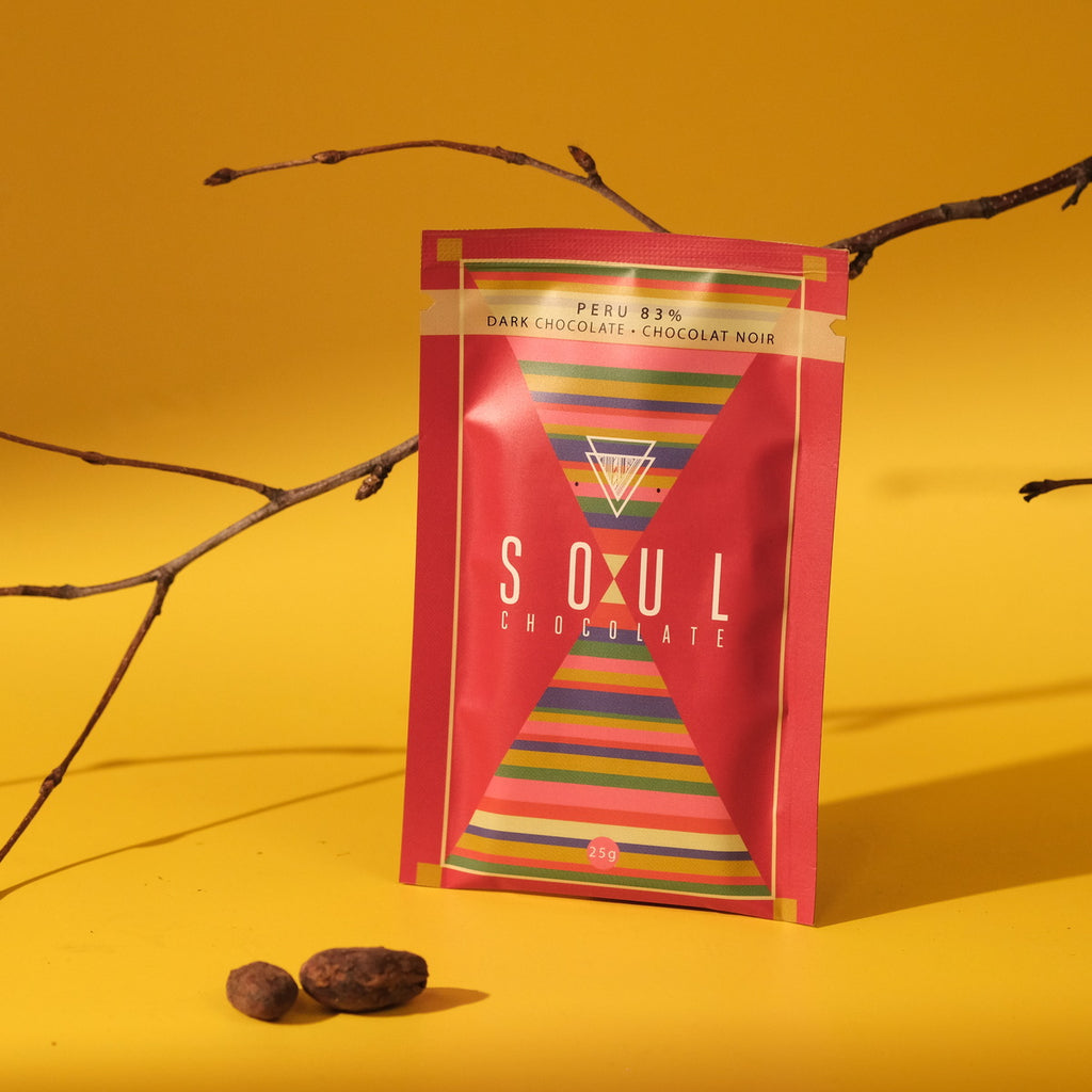 Soul Chocolate peruvian chocolate packaging with cocoa beans and a colorful design on a yellow background