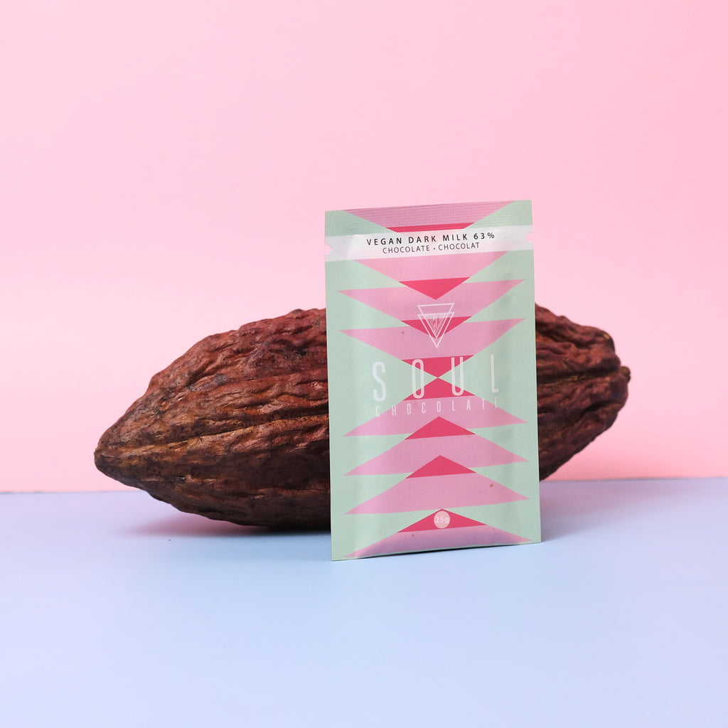 Soul Chocolate vegan chocolate bar packaging with a cacao pod on a pink and blue gradient background