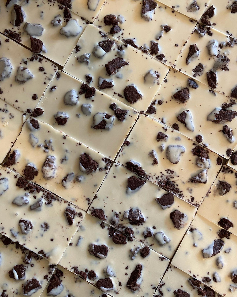 Chunks of homemade chocolate cookie sprinkled into a smooth white chocolate bar